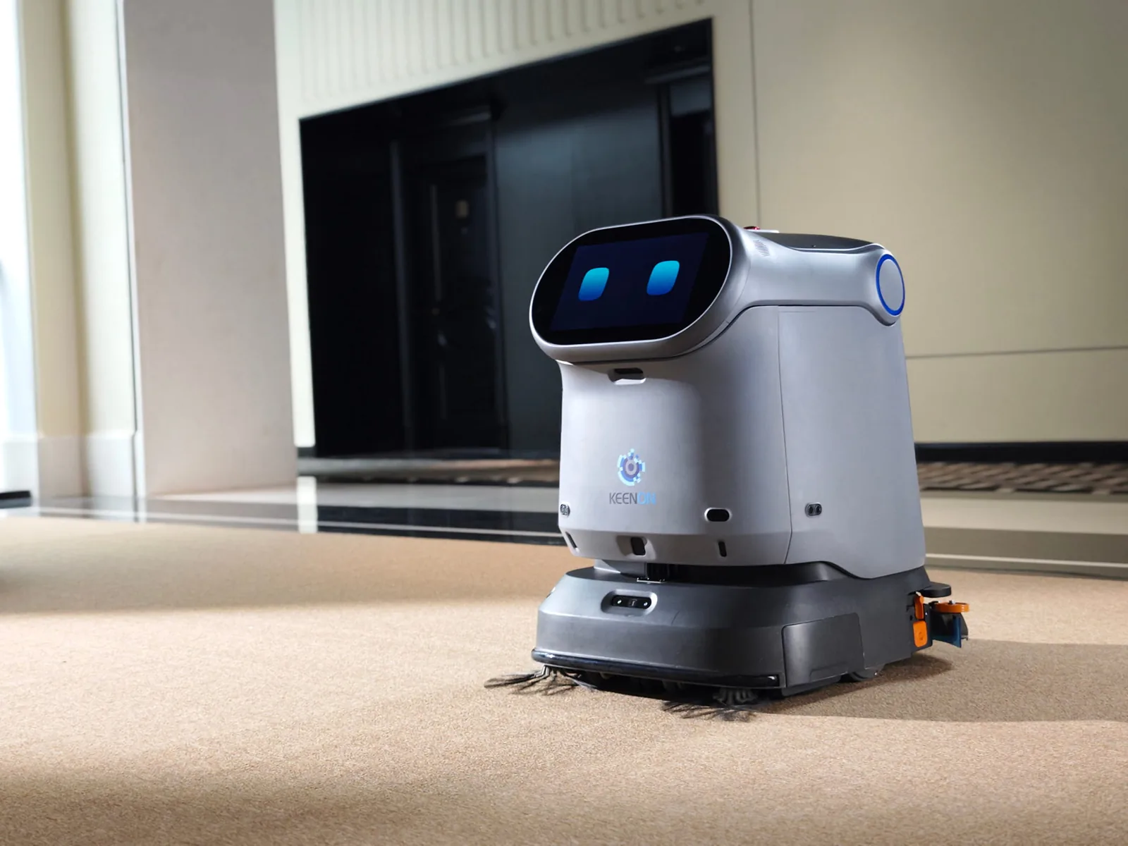Keenon C40 cleaning robot on carpet in a hotel lift lobby